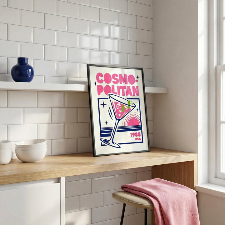 Cosmopolitan Cocktail Art Print print leaning on a wooden desk with white bowls and a blue vase nearby