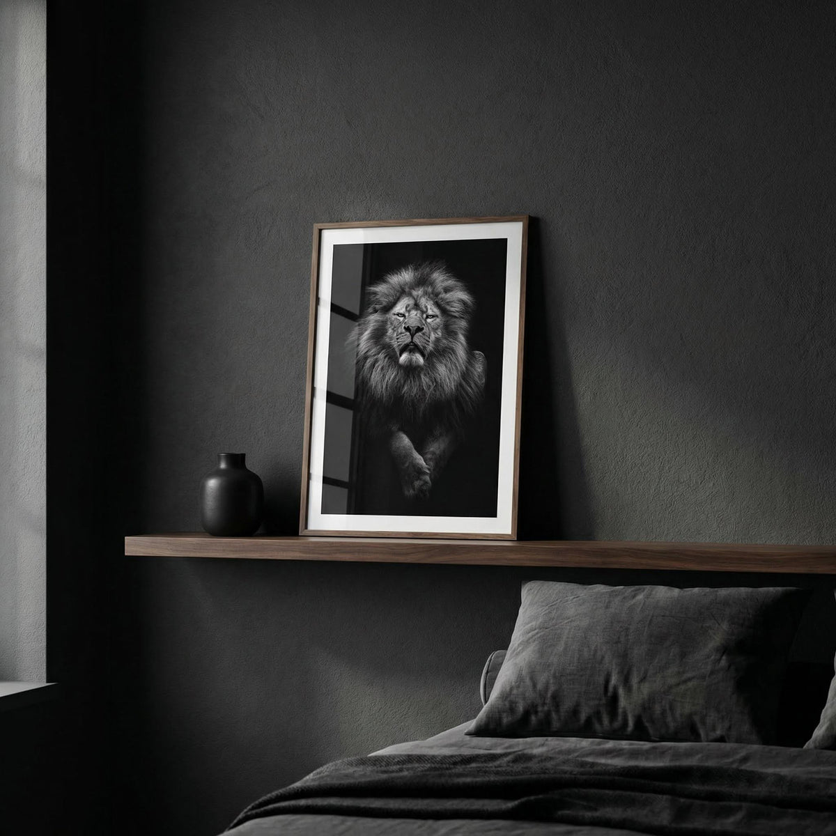 Print leaning on a shelf featuring a black lion art print with a dark background next to a black vase