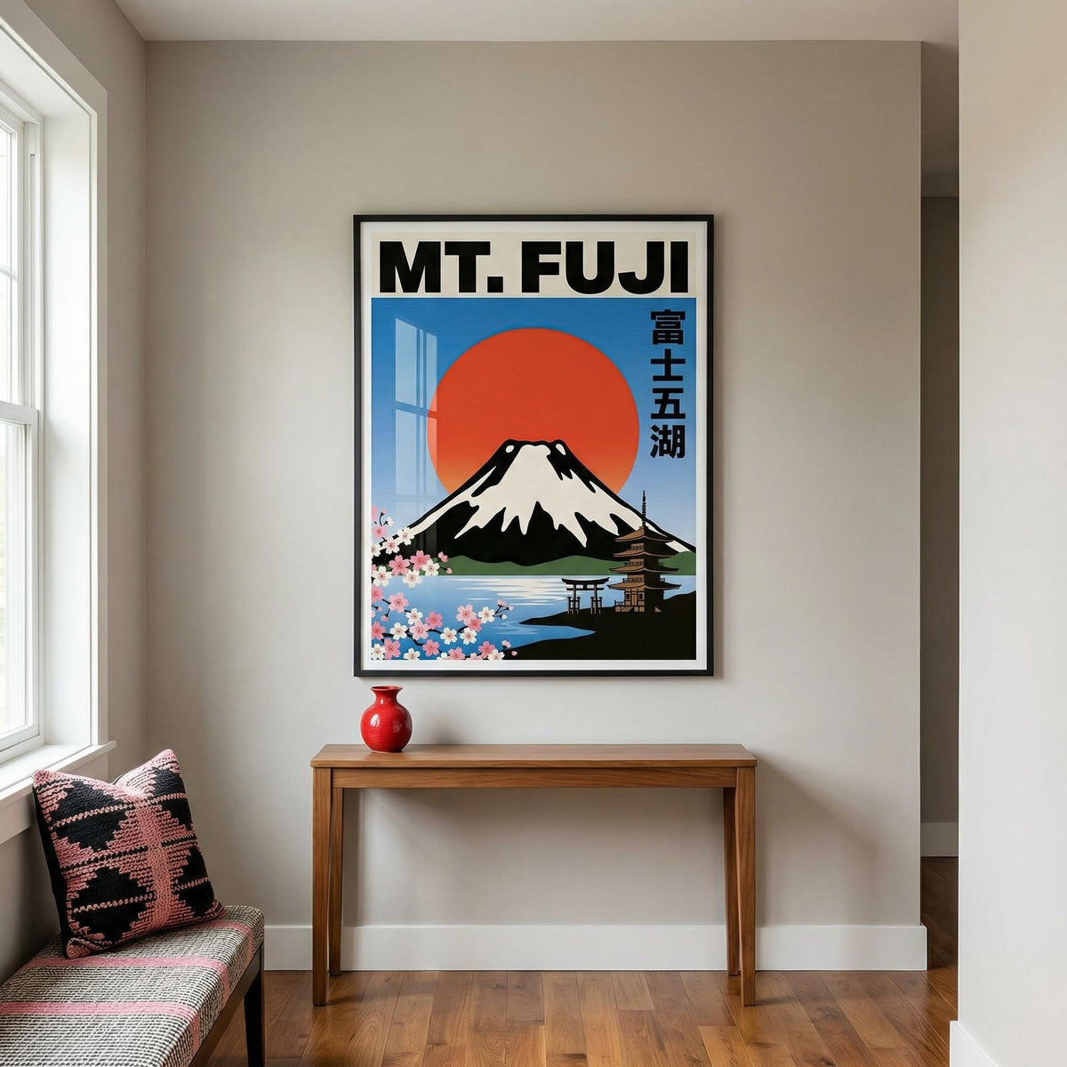 Mt Fuji wall art with red sun and cherry blossoms above a wooden console table with a red vase