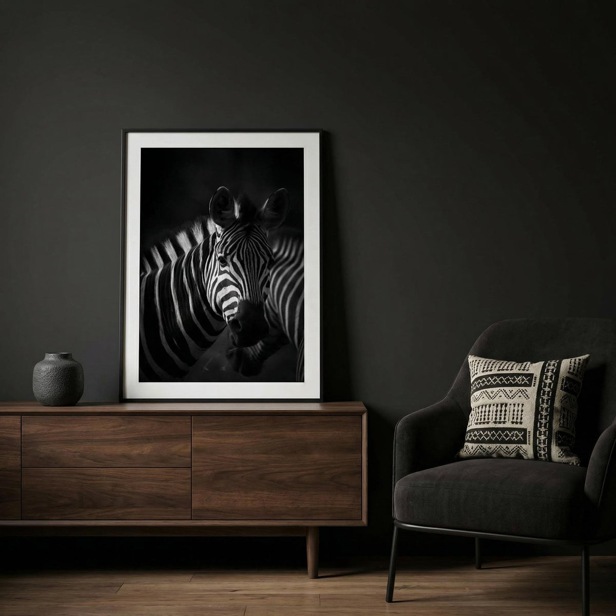 Framed Zebra Black White Print with black and white stripes above a wooden sideboard and next to a dark grey armchair
