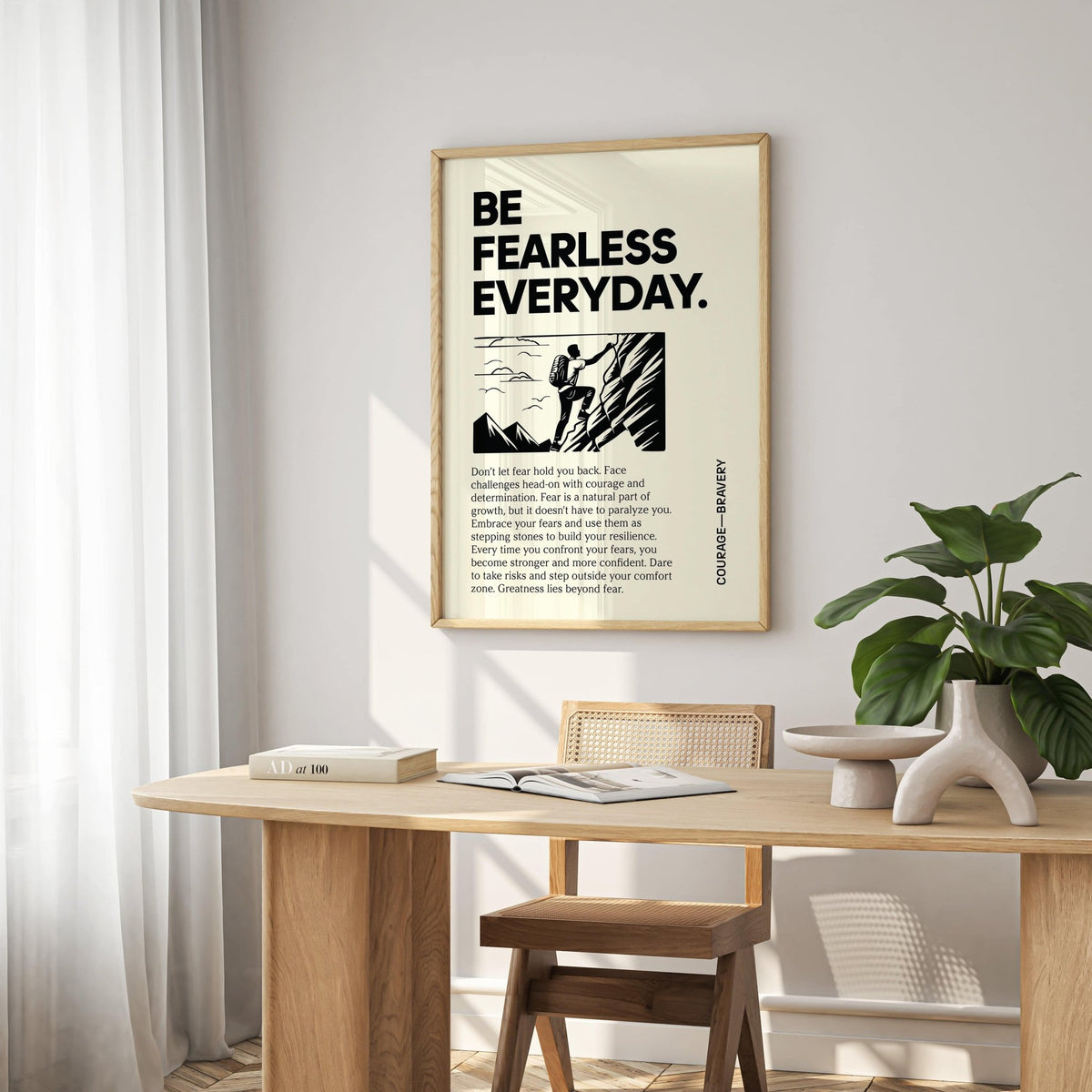 Positive Poster Art framed print showing a rock climber illustration and motivational text above a wooden desk with a plant