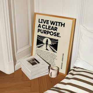 Motivational Poster print leaning on a wooden floor beside stacked books and a mug near a striped cushion