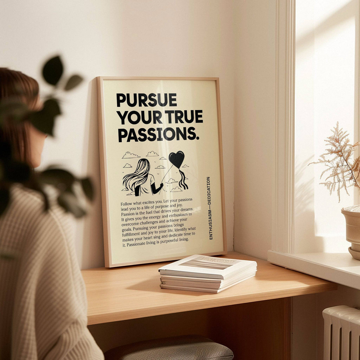 Print leaning on a shelf of a woman with heart balloon and bold text in black and cream near window