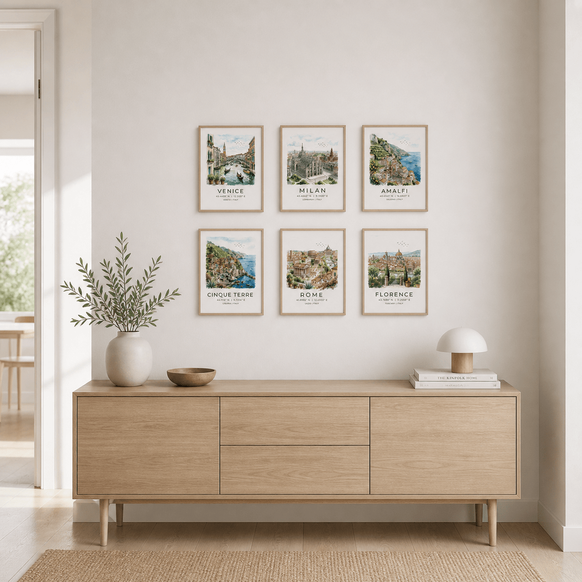Italy Travel Wall Art above a wooden sideboard with plant and lamp in a neutral room