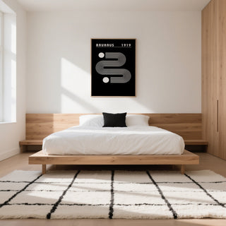 Black Minimalist Art print with white linear abstract shapes in a bedroom above a wooden bed
