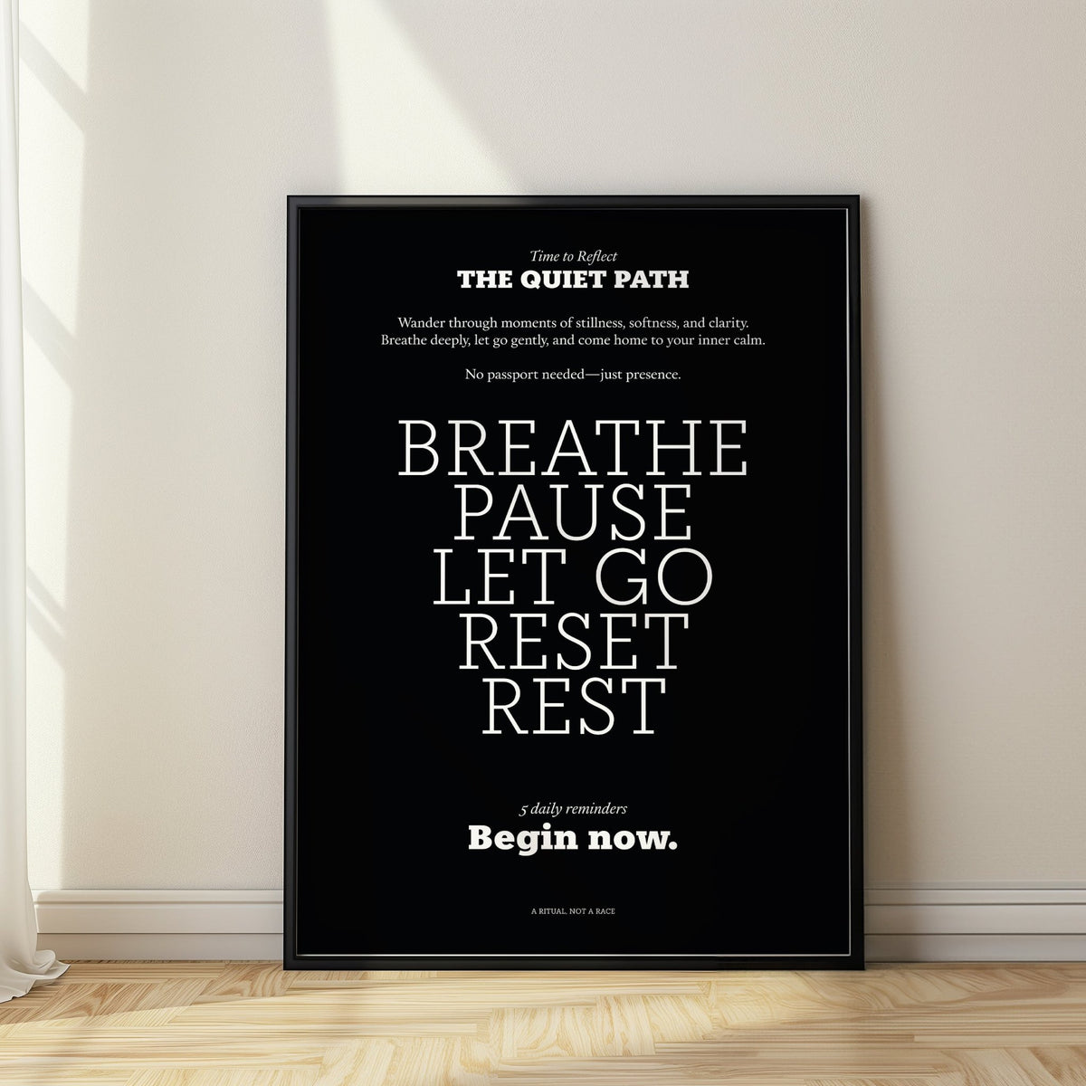 Meditation wall art with white text on a black background leaning on a wooden floor near a curtain