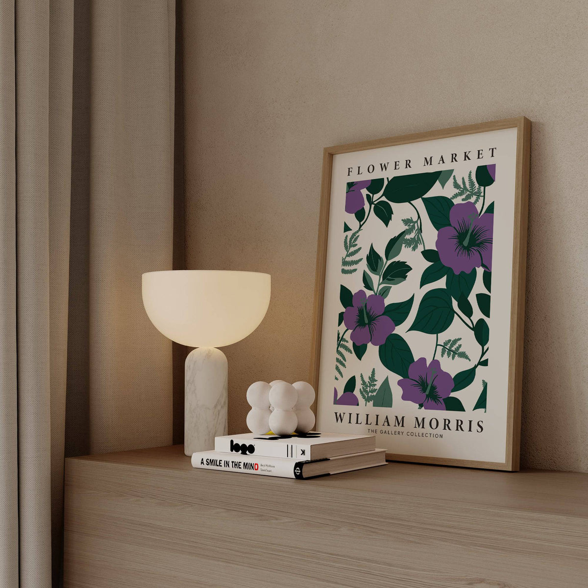 Purple Flower Artwork print leaning on a wood shelf with a lamp and books nearby