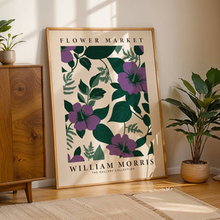 Purple Flower Artwork print leaning on a wooden floor with a green potted plant nearby