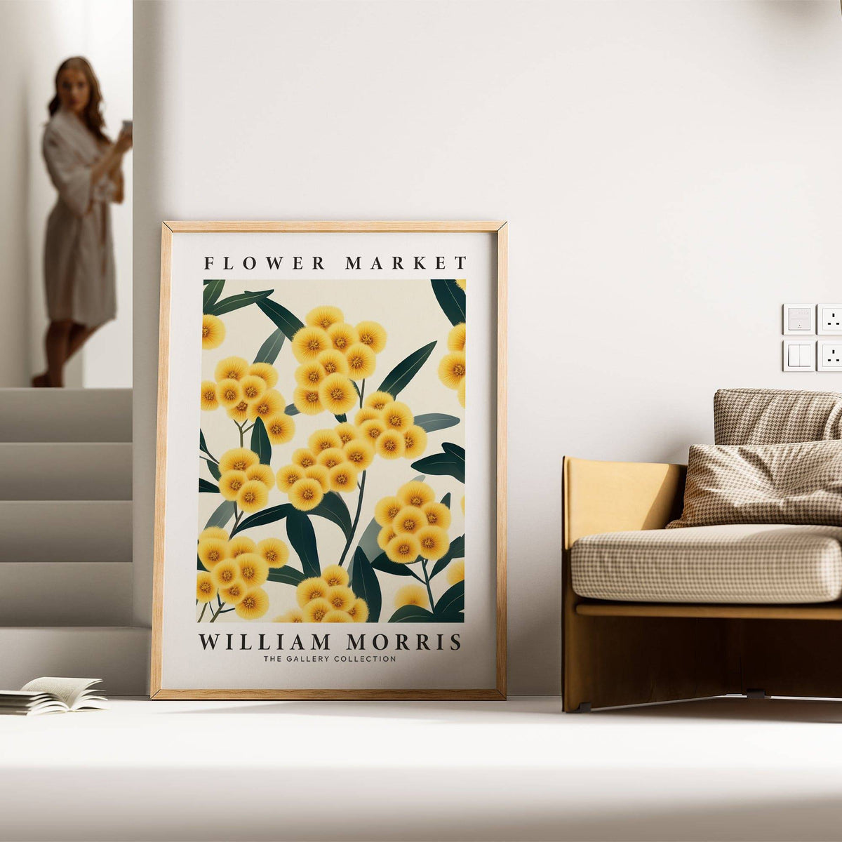 Yellow flower wall art with yellow pompom flowers in a wood frame leaning on the floor by a beige sofa