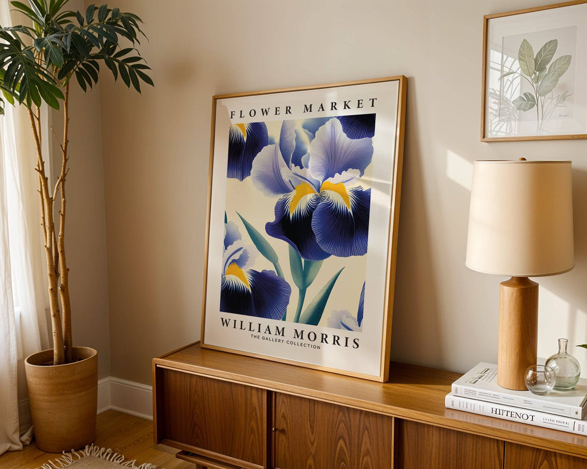 Purple flower wall art with blue iris flower in a vintage style leaning on a wooden sideboard next to a lamp