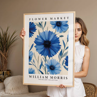 Framed Botanical Print of blue flowers held by a woman with a plant in the background