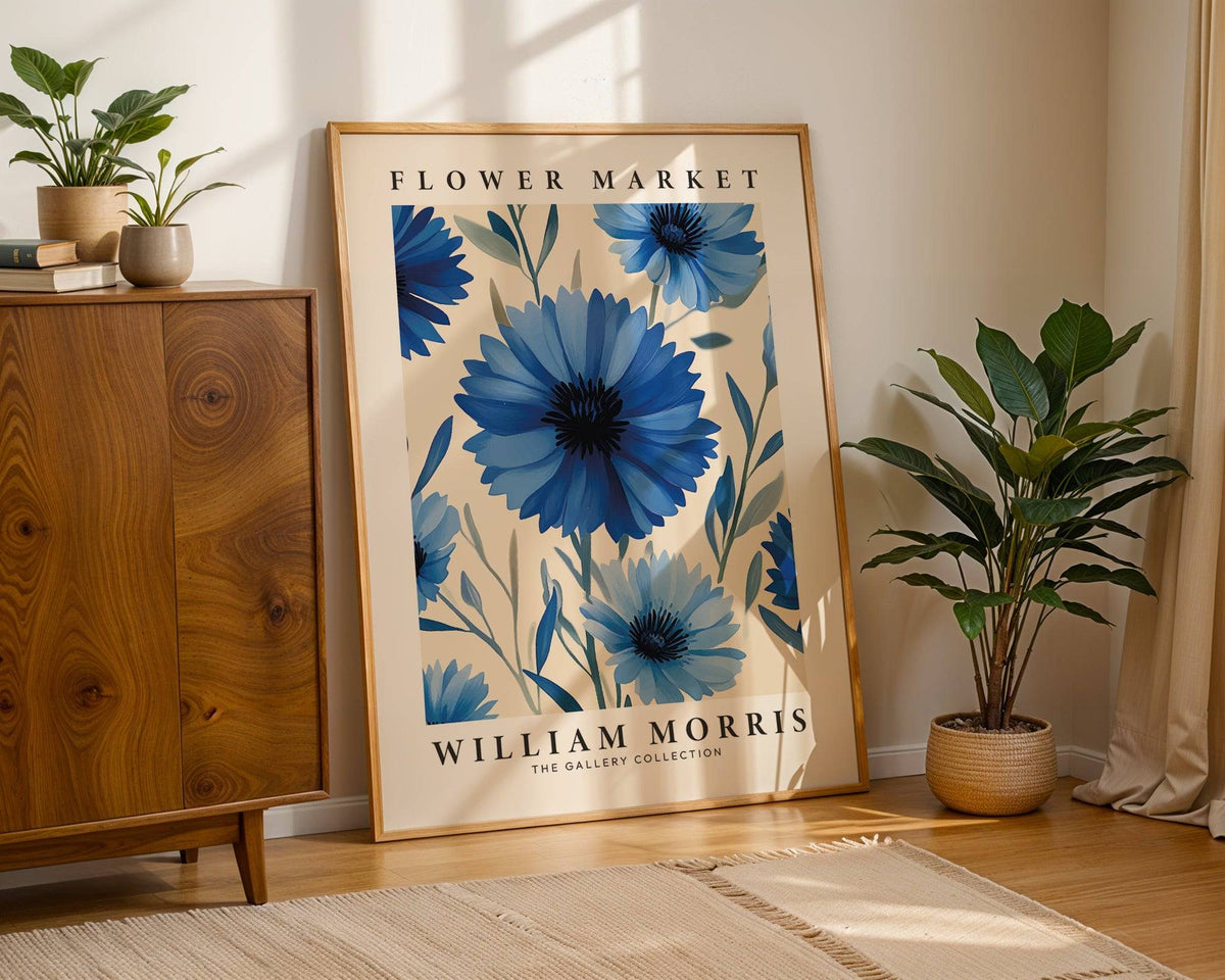 Botanical print leaning on floor with wooden sideboard and potted plant nearby in soft light