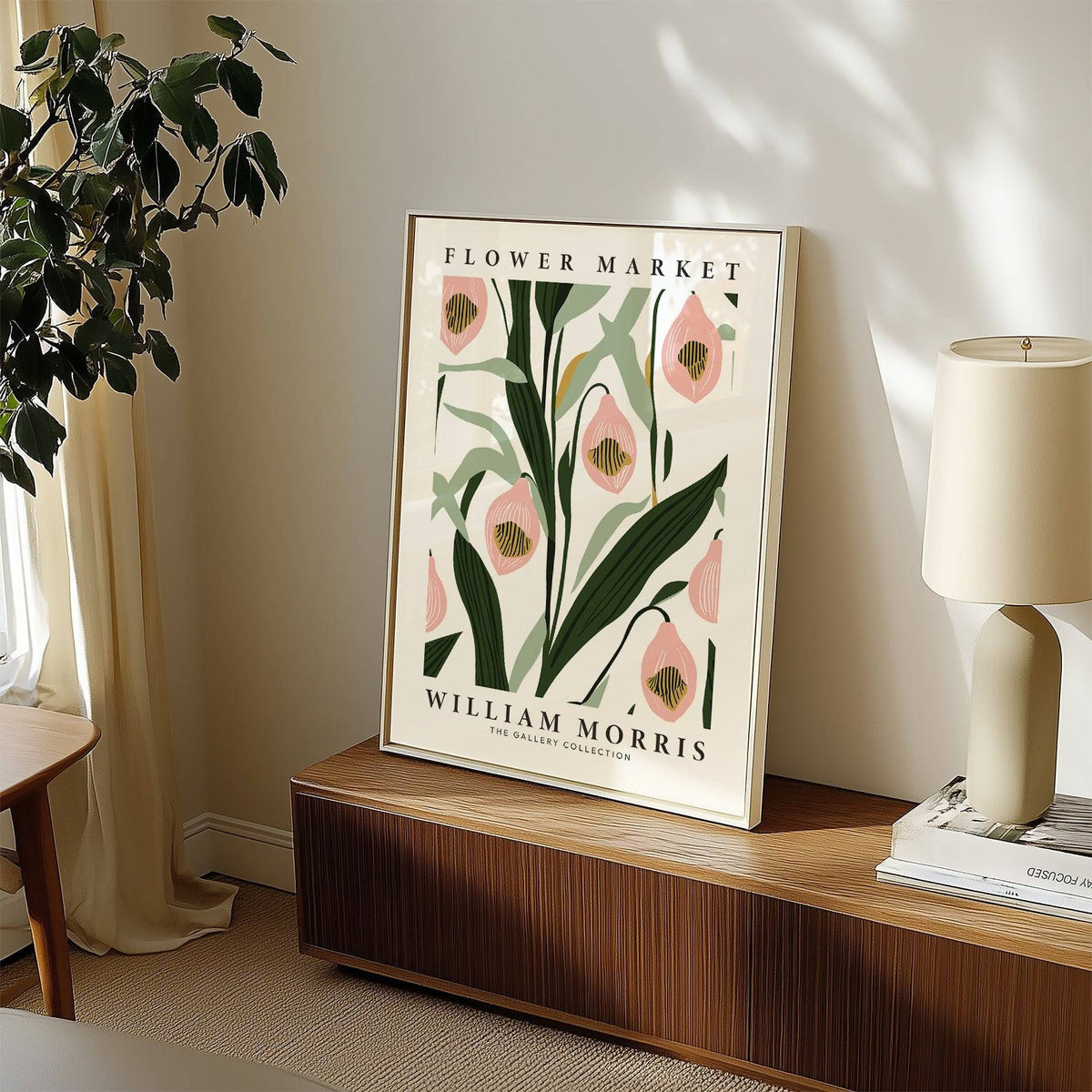 Paintings of Orchids leaning print of pink orchids with green leaves beside lamp on a wooden sideboard