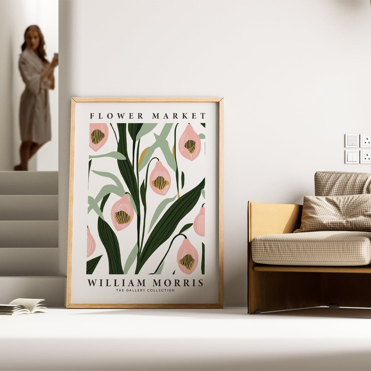 Print leaning on a floor by a sofa showing pink orchid flowers and green leaves in minimalist style