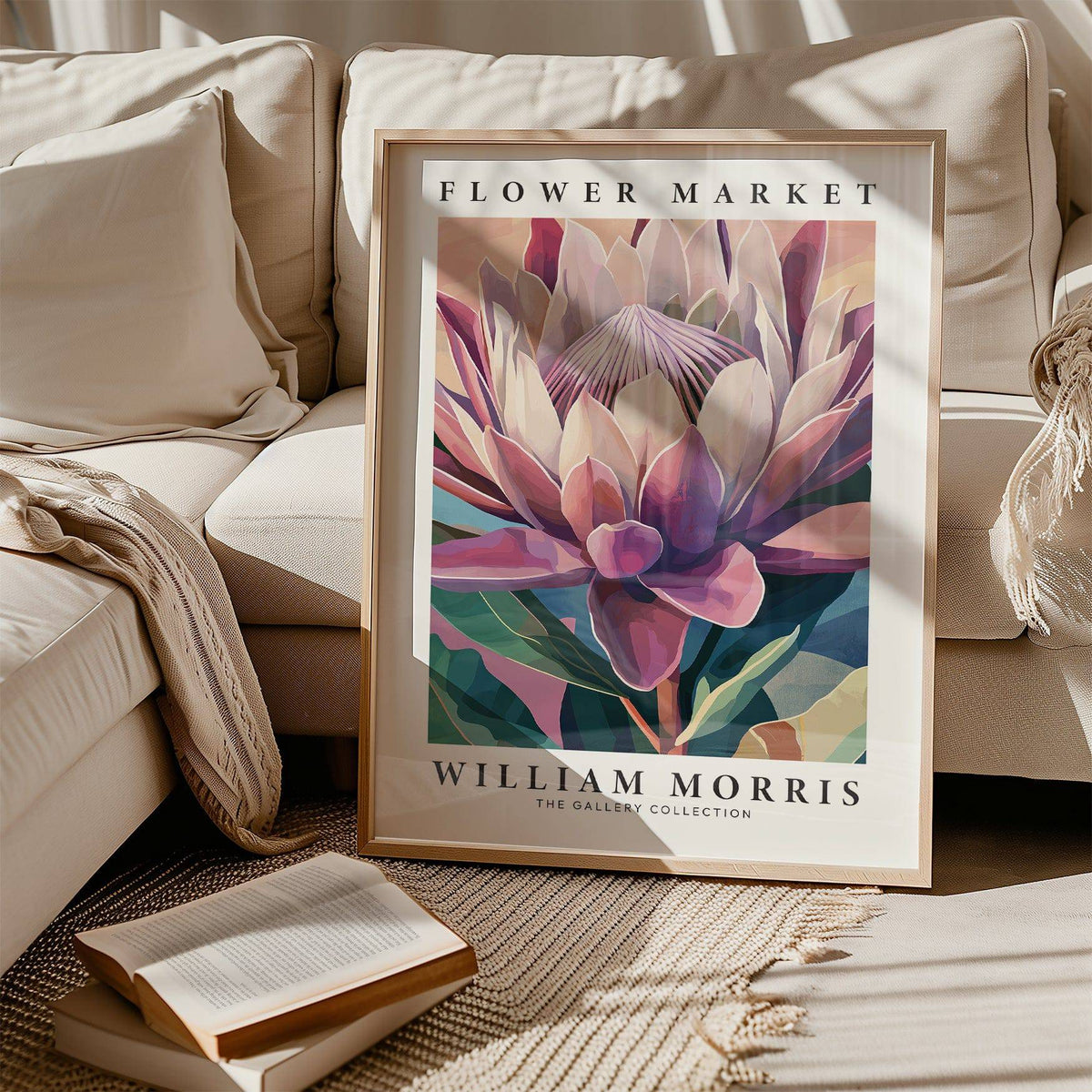 Flower wall art with king protea illustration in pink and green tones leaning on a beige sofa with cushions