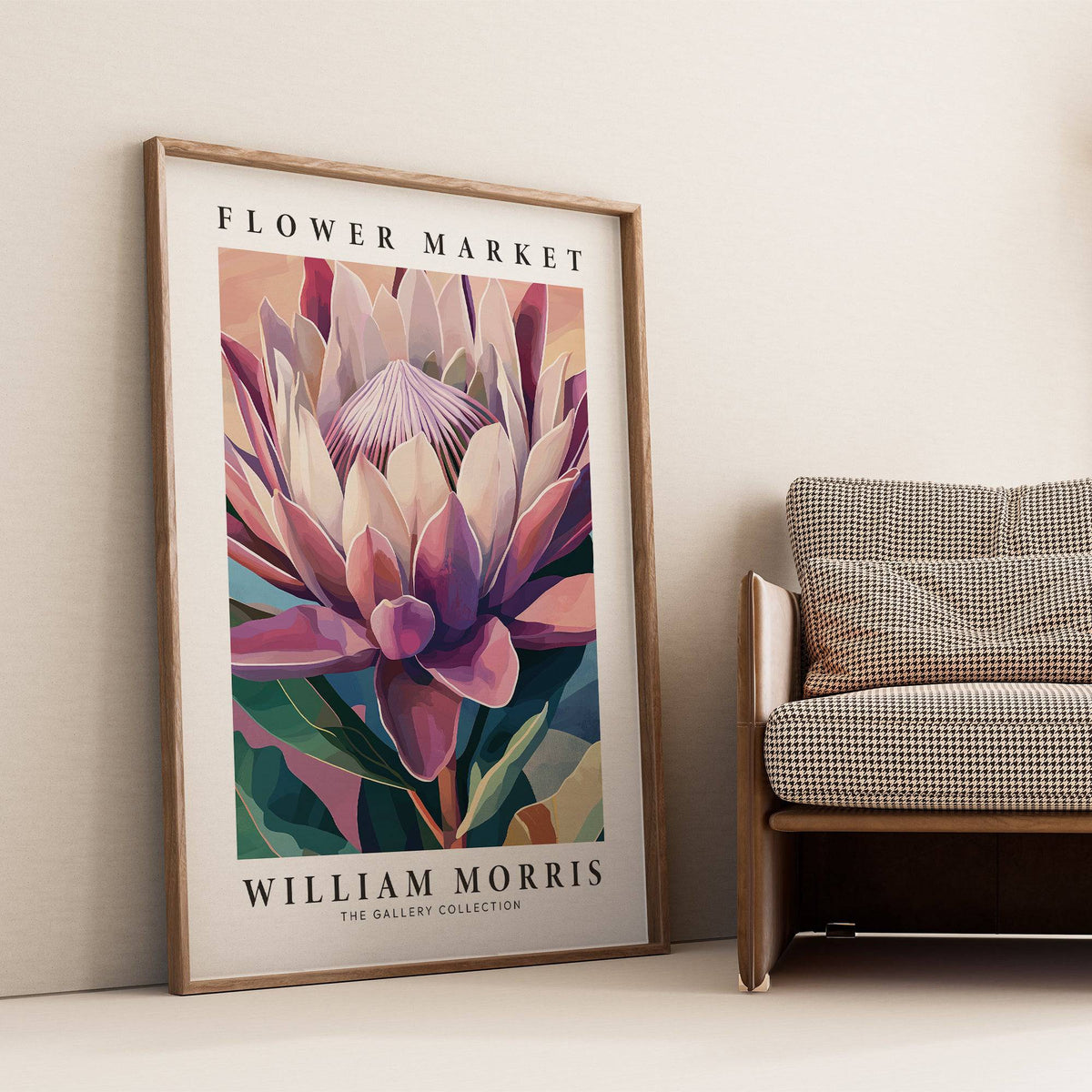 Flower wall art of a king protea flower with muted pinks and greens leaning against a wall beside a patterned chair