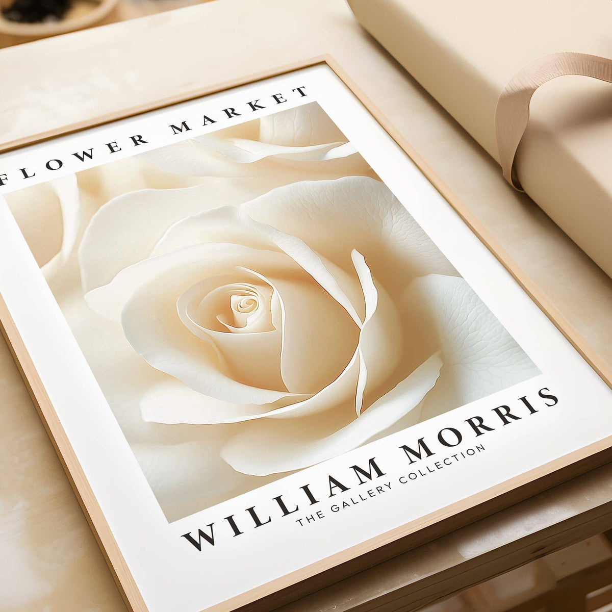 Framed close-up of a cream rose with William Morris text and a beige gift box nearby
