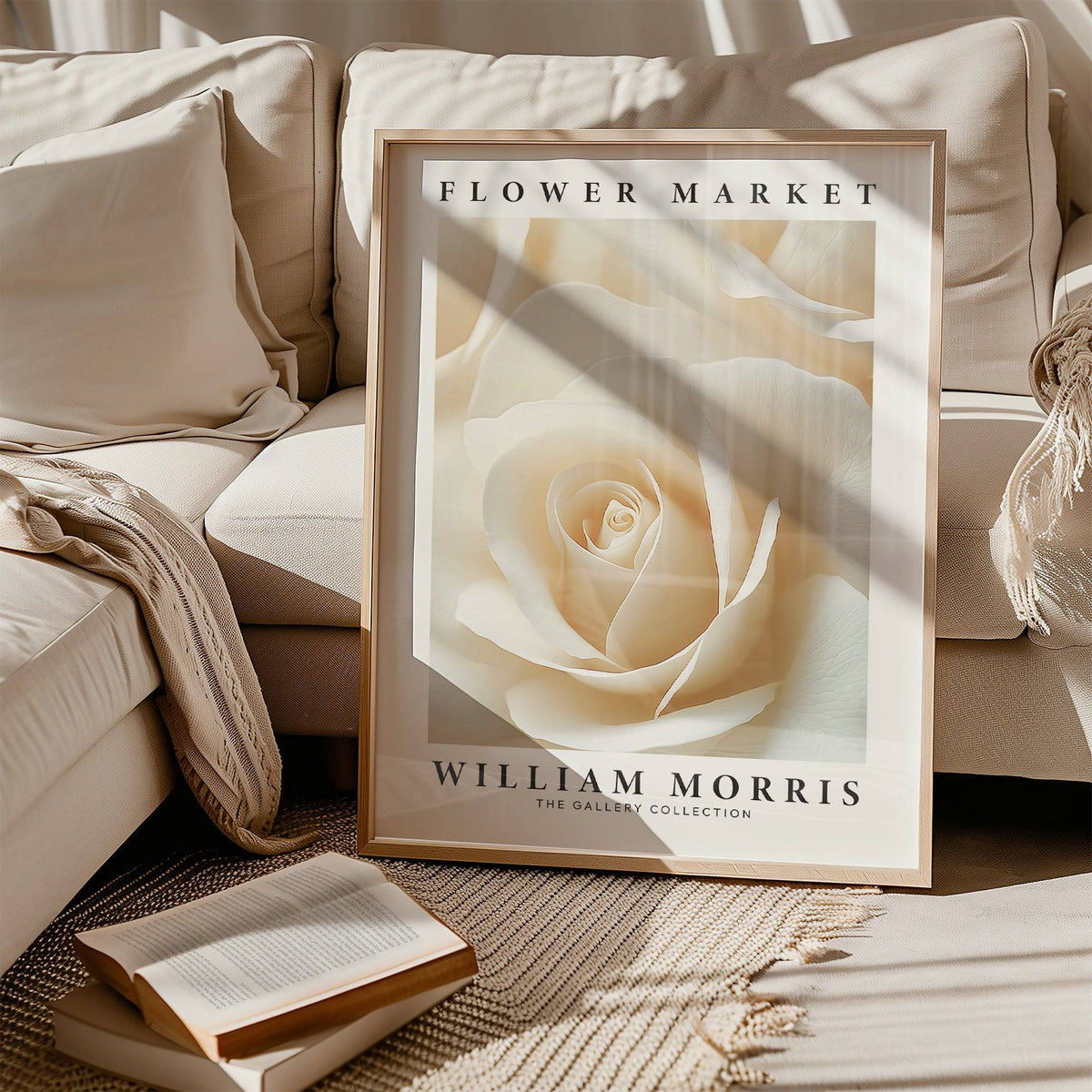 Print leaning on a sofa featuring cream rose close-up floral wall art with soft shadows and a book nearby