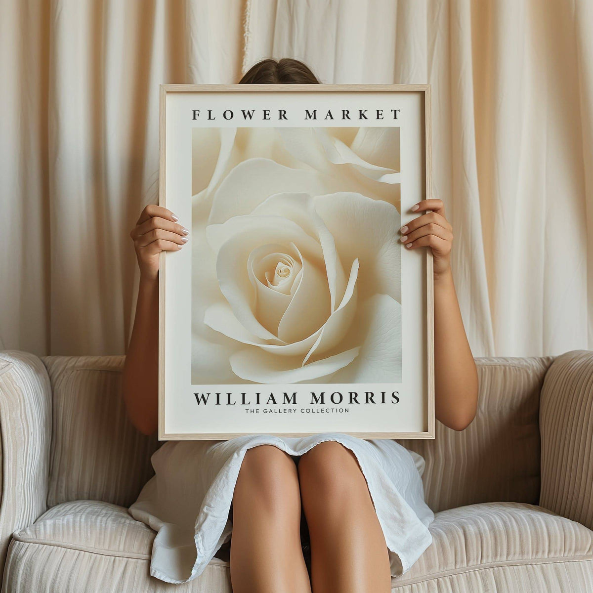 Floral wall art for living room held by a person seated on a cream sofa with curtains behind