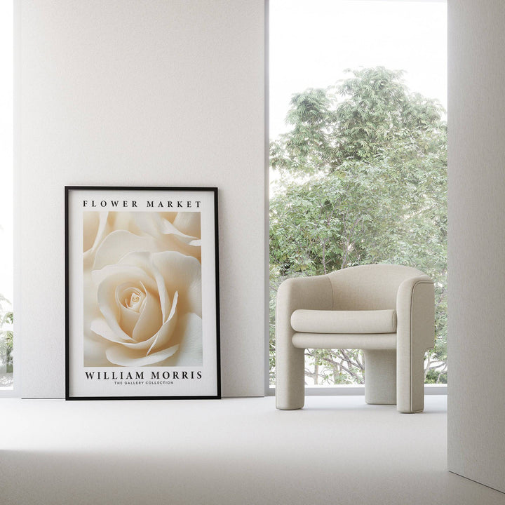 Floral wall art for living room cream rose close-up print leaning on the floor near a beige armchair