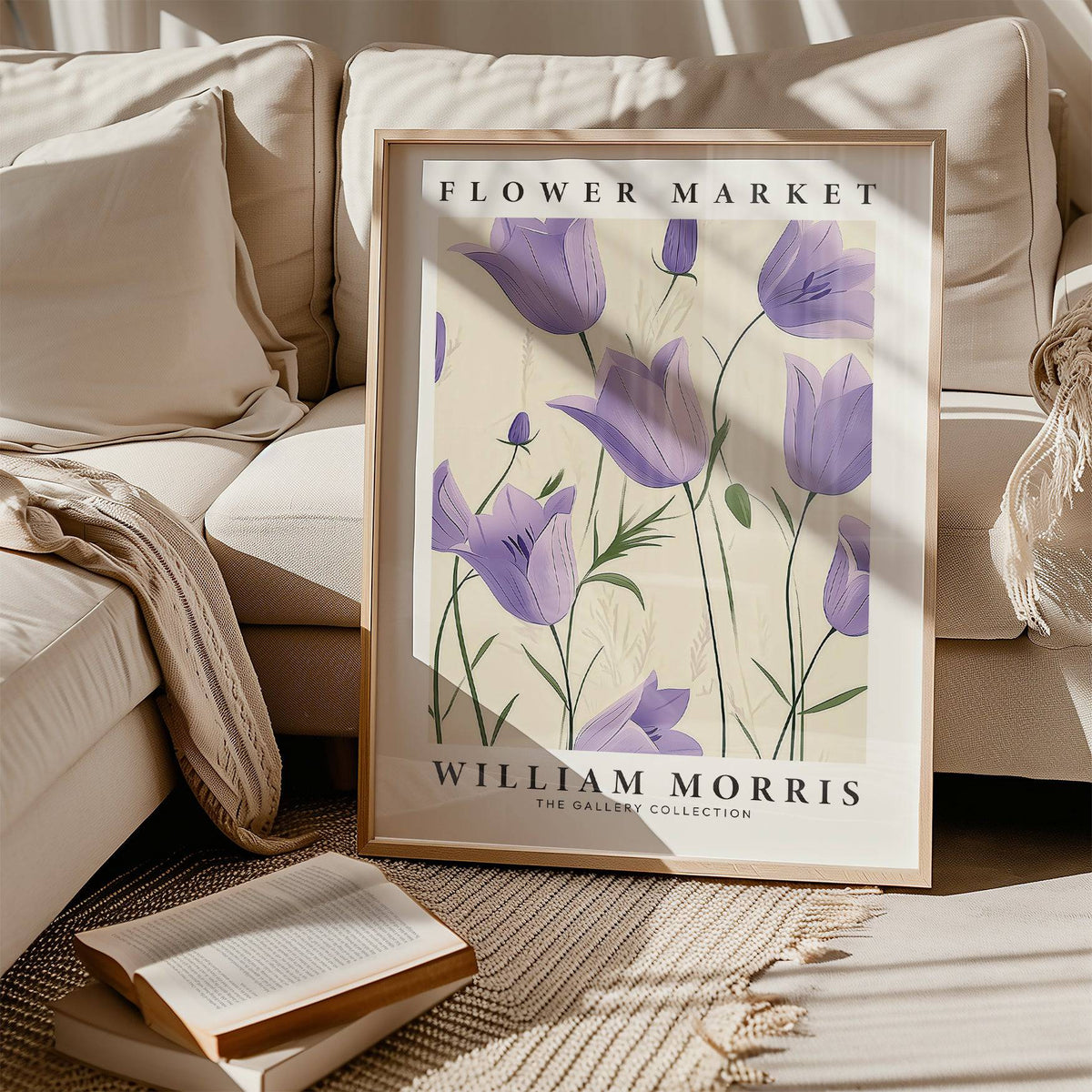 Framed Wall Art Tulips print with purple bell flowers resting on a beige carpet near a sofa and an open book