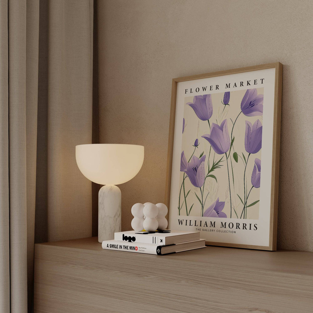 Print leaning on a shelf with purple bell flowers illustration and a lit lamp nearby
