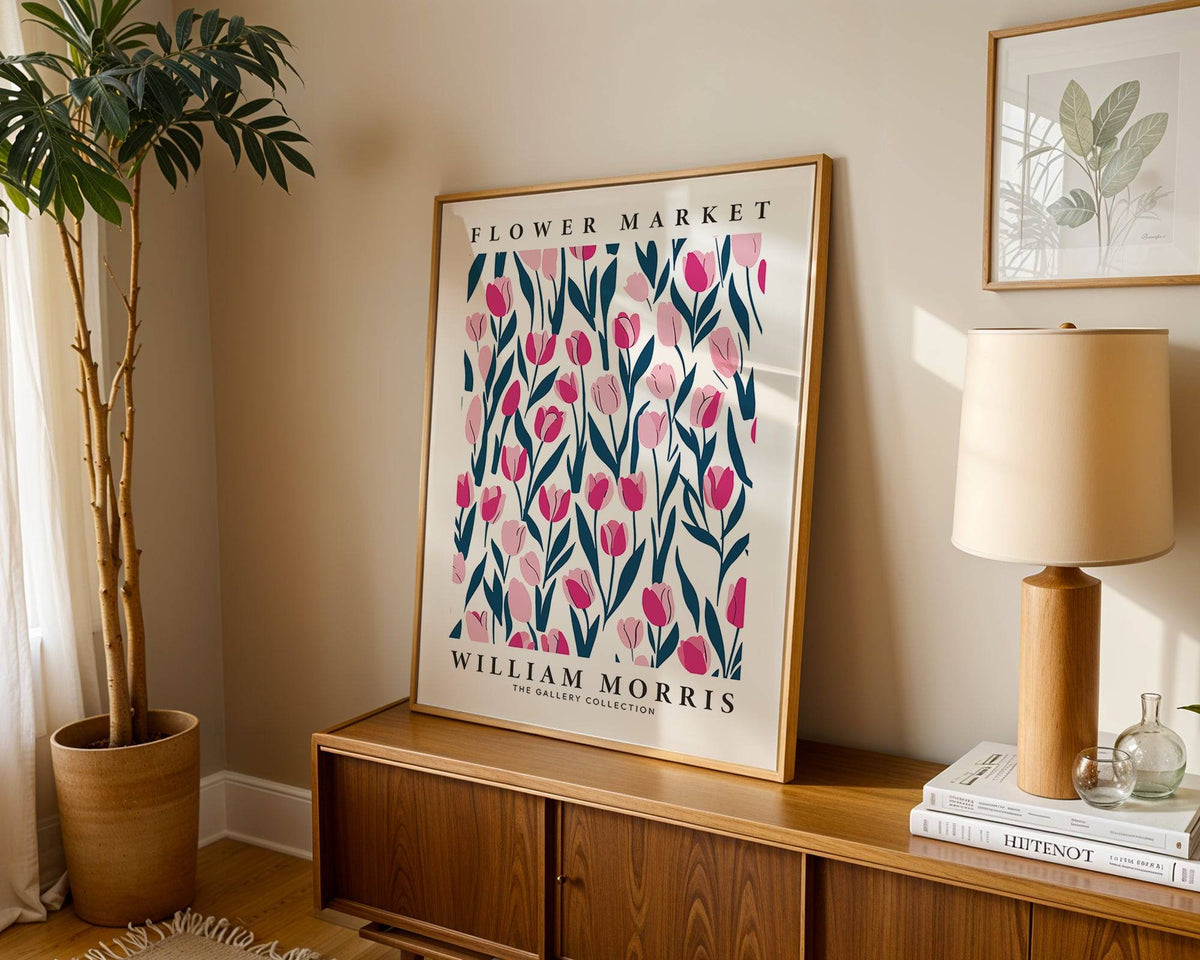 Tulip decor print leaning on a wooden sideboard with a lamp and potted plant in soft natural light