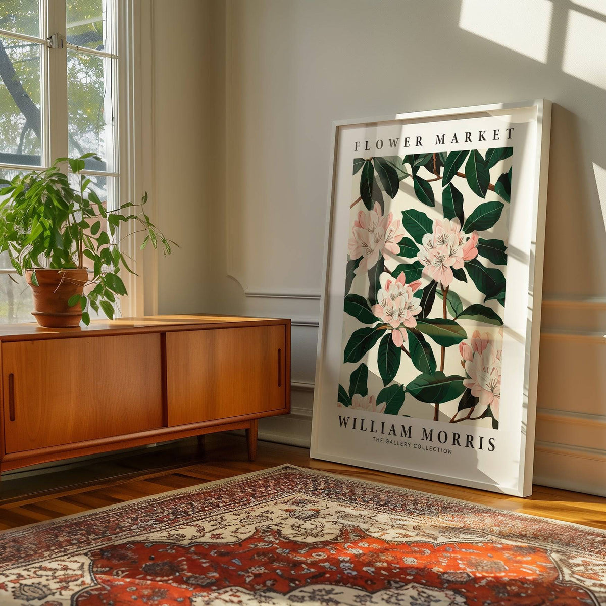 Magnolia wall art print leaning on floor with pink flowers and green leaves near wooden sideboard and plant