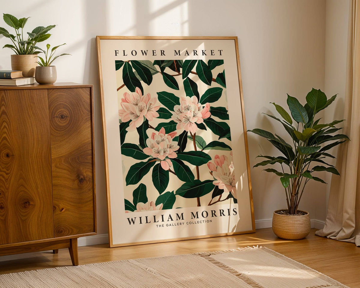 Magnolia wall art print leaning on the floor with sunlight casting shadows and a plant nearby