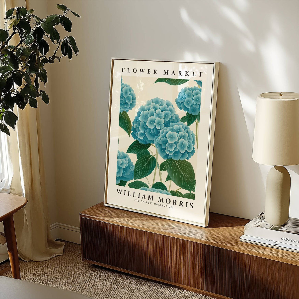 Flower Market Prints leaning print of blue hydrangea flowers on a wooden sideboard with a lamp and plant