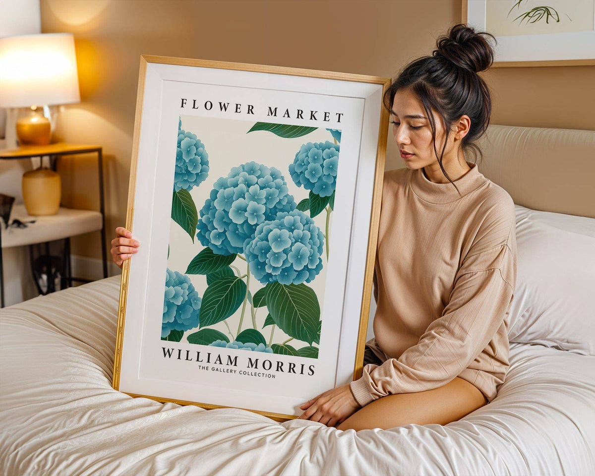 Framed Flower Market Prints with blue hydrangea flowers held by a woman on a bed