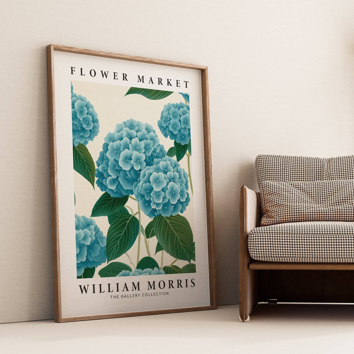 Flower Market Prints leaning print of blue hydrangea flowers with green leaves beside a grey patterned armchair
