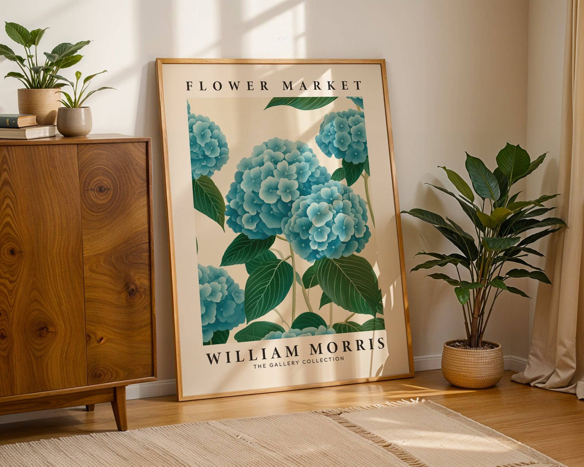 Flower Market Prints leaning print of blue hydrangea flowers in a beige and green colour scheme beside a houseplant