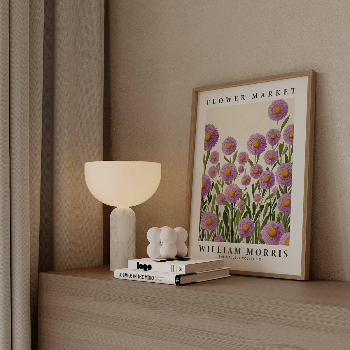Purple floral wall art of purple daisies leaning on a wooden shelf next to a round white lamp