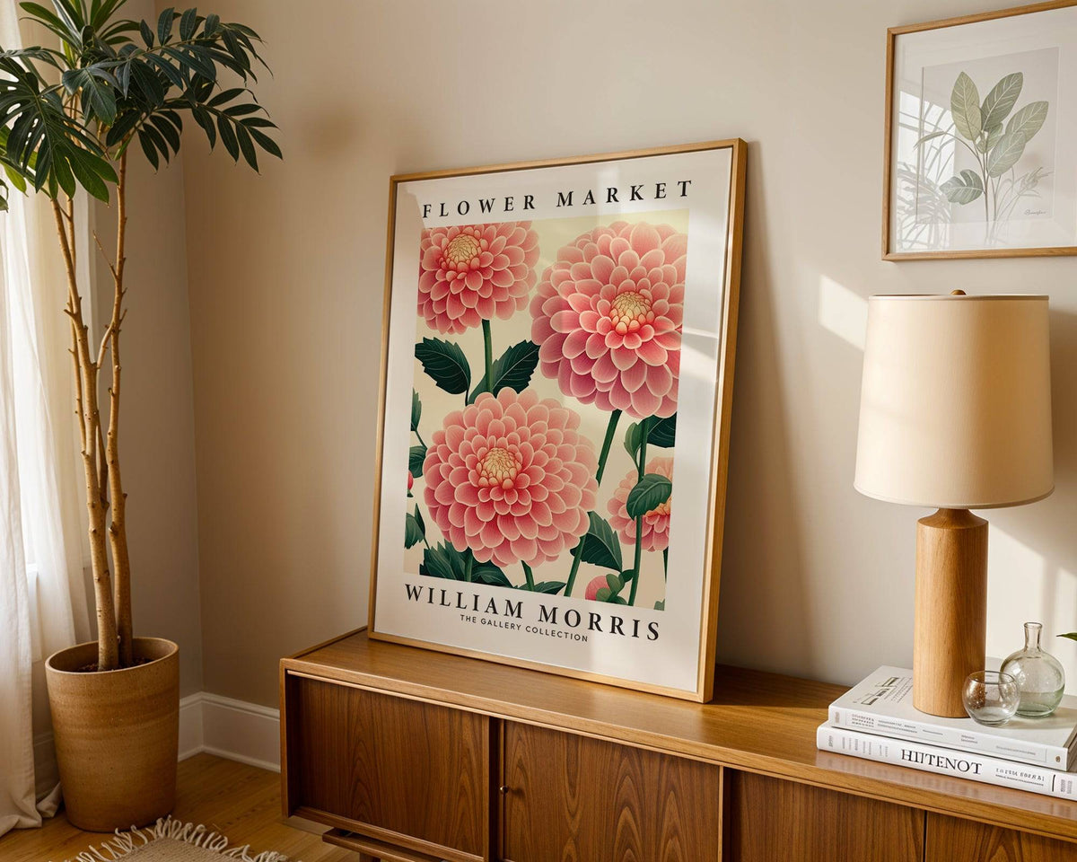 Pink wall decor leaning on a wooden sideboard with beige lamp and plant in neutral room
