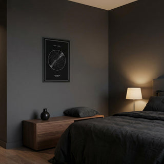Custom Star Map framed print in a dark bedroom with a wooden bedside cabinet and lamp
