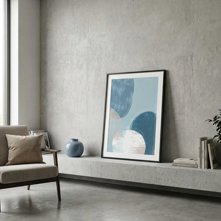 Abstract blue art print with overlapping circles leaning on a shelf with a blue vase nearby