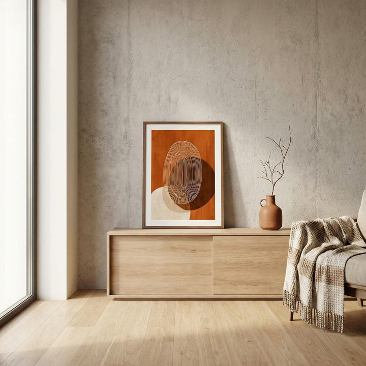 Modern Geometric Print leaning on a wooden sideboard with a terracotta vase and a branch in a neutral room