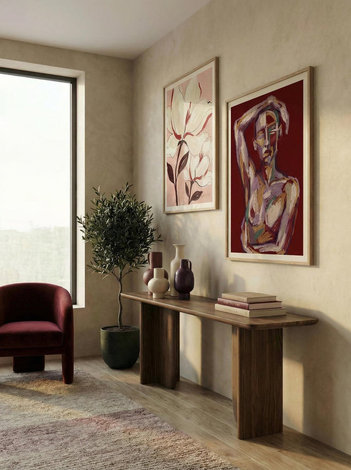 Print on a wall of an abstract female figure in red and pink tones with a plant beside in a living room