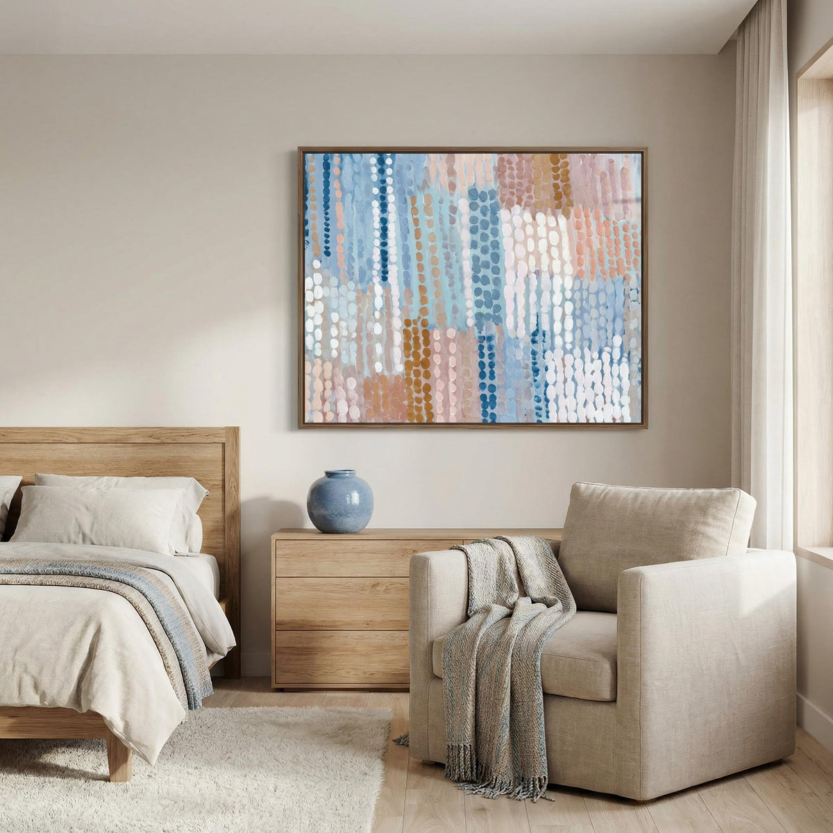 Pastel blue and pink abstract prints framed in a bedroom above a wooden dresser with a blue vase
