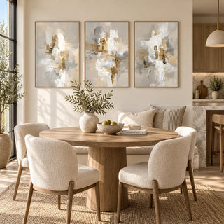Neutral dining room wall art of abstract neutral shapes hanging above a round wooden table with four cream chairs