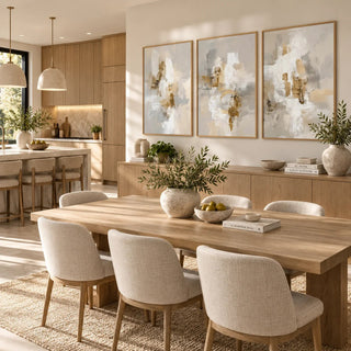 Neutral dining room wall art with three abstract beige and grey prints above wooden sideboard with plants