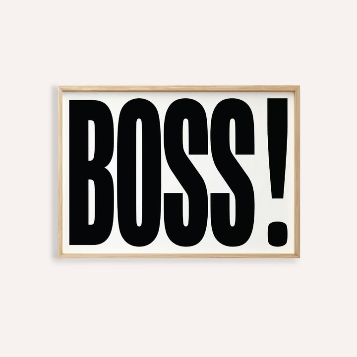 Office wall art with bold black boss typography on white background in a light wood frame