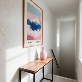 Print of Mount Fuji Art with an abstract pink and blue mountain above a wooden console with a pink vase