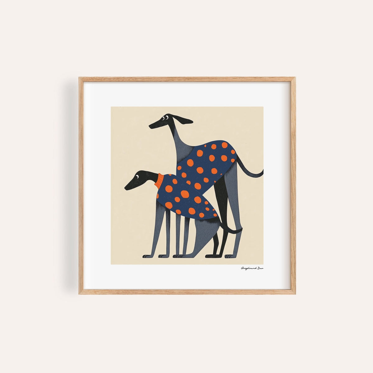 Framed print close-up of two greyhounds in orange polka dot coats on cream background