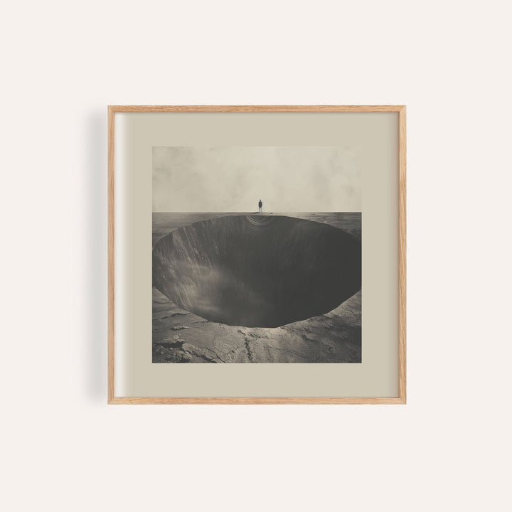 Framed Surrealist wall art of a figure standing by a dark abyss hole in muted greys