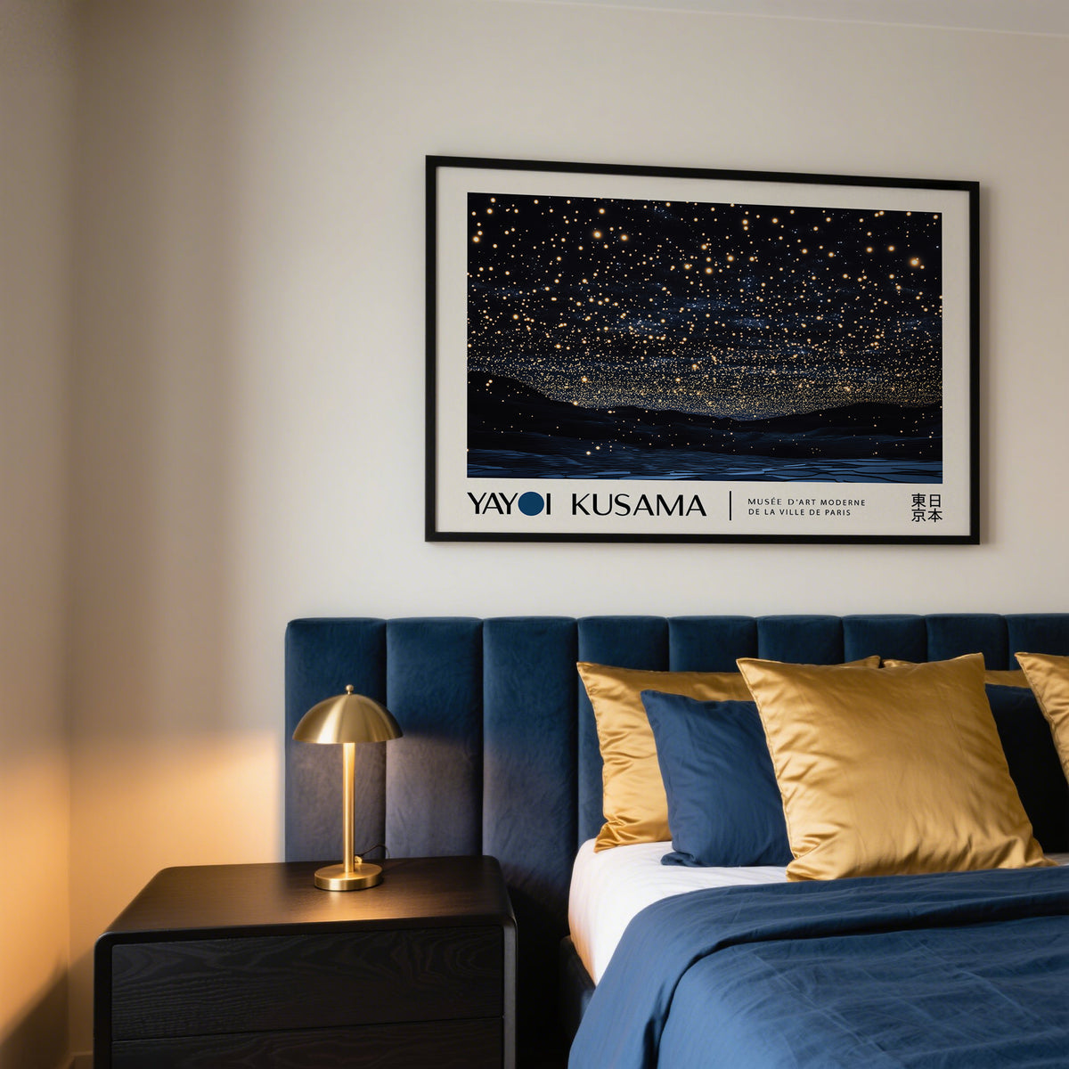 Night Sky Art framed print of a starry night sky with gold and dark blue hues above a bedside table lamp