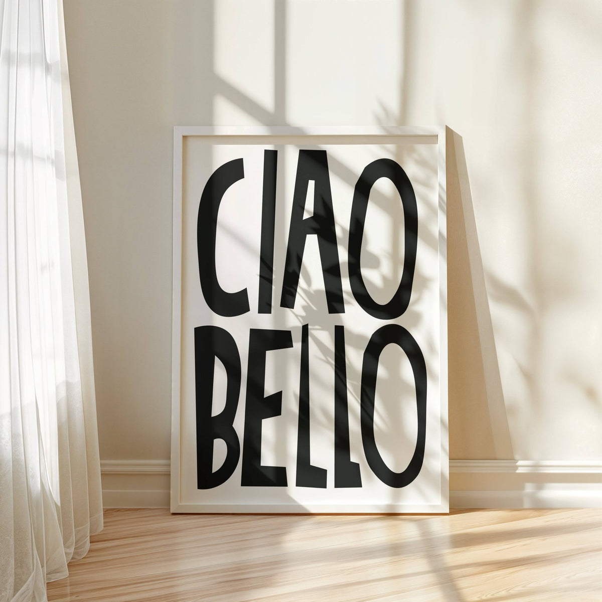 Print leaning on a floor with ciao bello text in black on white with natural light and curtain