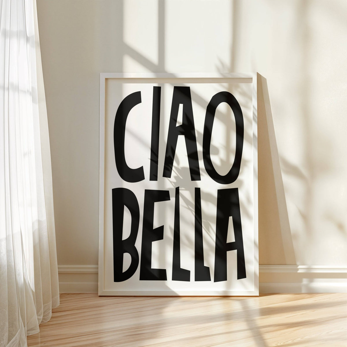 Black and White Typography Poster leaning against a beige wall with shadows and light wooden floor