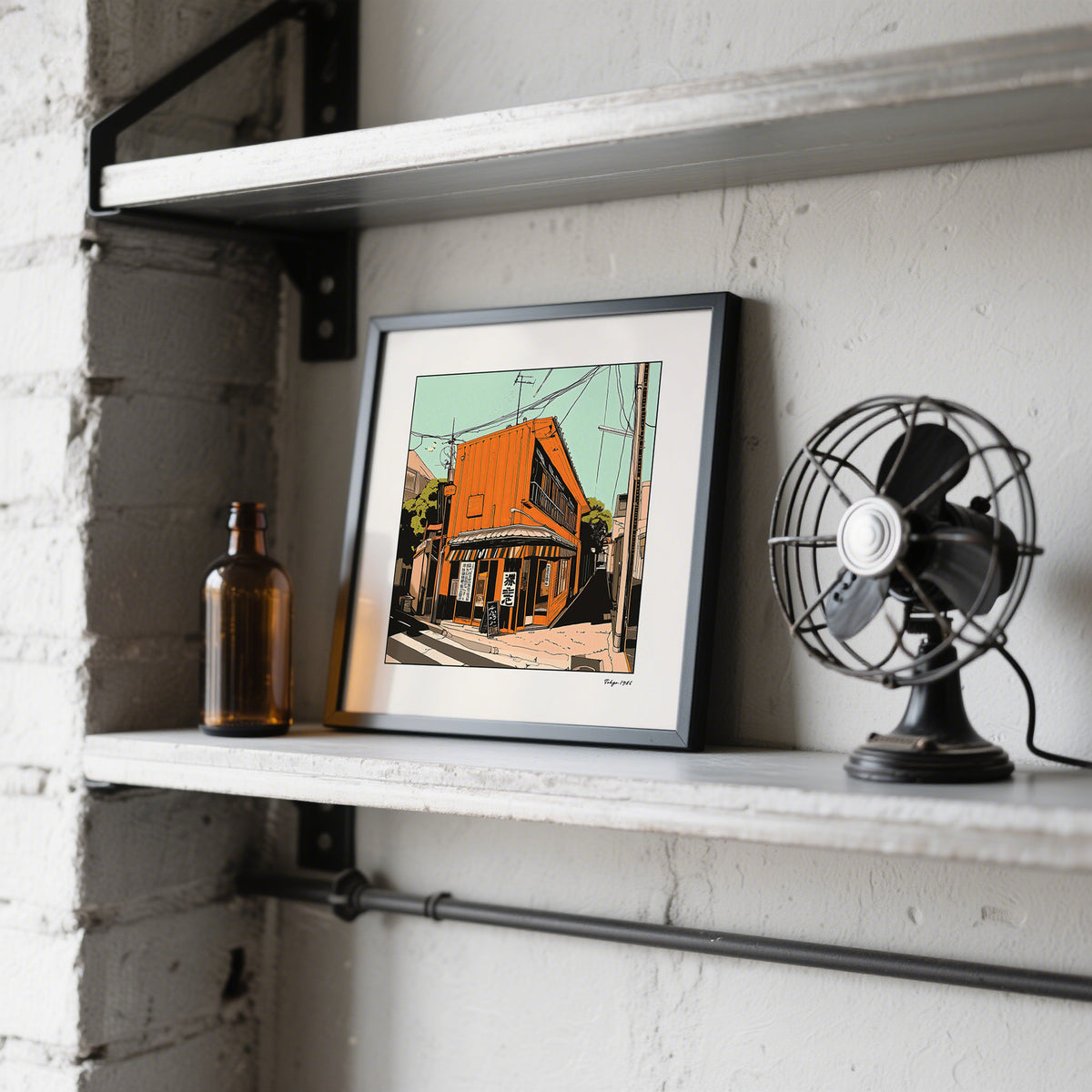 Tokyo wall art leaning on a shelf with a vintage fan and brown glass bottle nearby